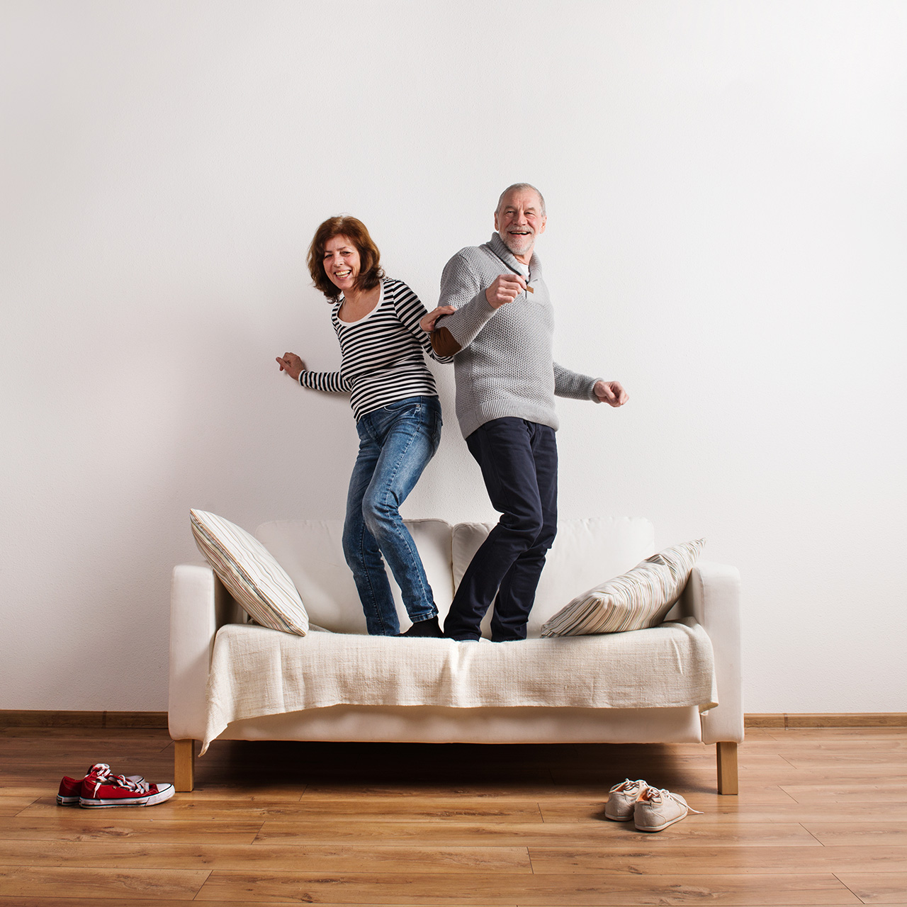 A pain-free couple dances on their couch.